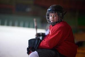 Kinder-Eishockeyspieler auf der Bank foto