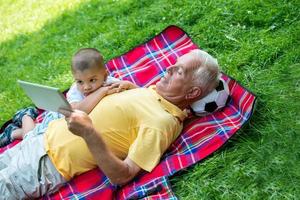 großvater und kind im park mit tablet foto