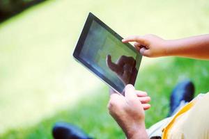 großvater und kind im park mit tablet foto