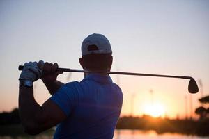 Golfspieler, der einen langen Schuss schlägt foto