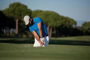 Profigolfer, der einen Sandbunkerschlag schlägt foto