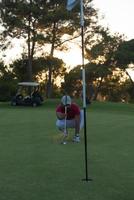 golfspieler, der einen perfekten schuss auf einen wunderschönen sonnenuntergang anstrebt foto