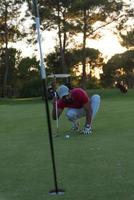 golfspieler, der einen perfekten schuss auf einen wunderschönen sonnenuntergang anstrebt foto