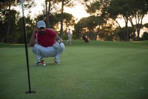 golfspieler, der einen perfekten schuss auf einen wunderschönen sonnenuntergang anstrebt foto