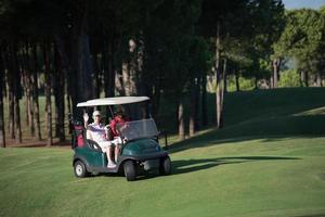 Paar im Buggy auf dem Golfplatz foto