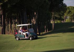 Paar im Buggy auf dem Golfplatz foto