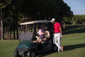 Paar im Buggy auf dem Golfplatz foto