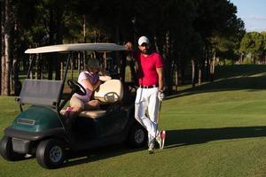 Paar im Buggy auf dem Golfplatz foto