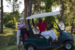 Paar im Buggy auf dem Golfplatz foto