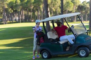 Paar im Buggy auf dem Golfplatz foto