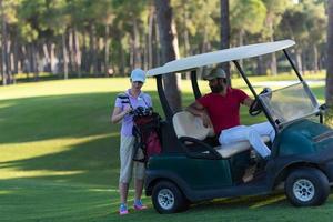 Paar im Buggy auf dem Golfplatz foto