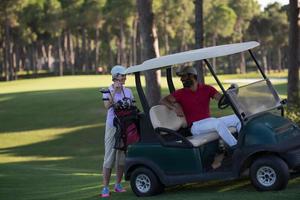 Paar im Buggy auf dem Golfplatz foto