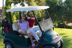 Paar im Buggy auf dem Golfplatz foto