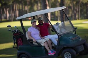 Paar im Buggy auf dem Golfplatz foto