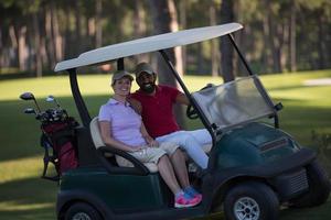 Paar im Buggy auf dem Golfplatz foto