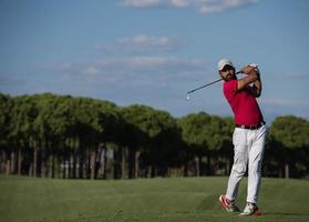 Golfspieler, der einen langen Schuss schlägt foto