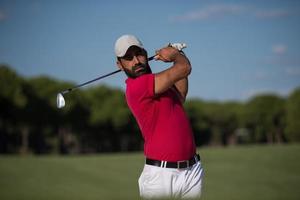 Golfspieler, der einen Sandbunkerschlag schlägt foto