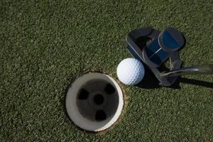 Golfball ins Loch schlagen foto