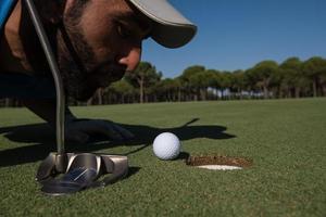 Golfspieler bläst Ball ins Loch foto