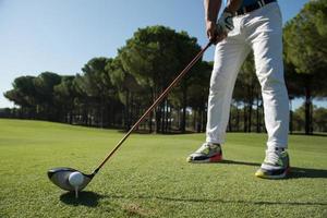 Golfspieler platziert Ball auf Tee foto