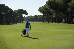 golfspieler, der mit radtasche geht foto