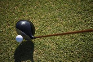 Golfschläger und Ball im Gras foto