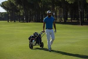 golfspieler, der mit radtasche geht foto