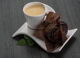 Kaffee mit Muffin auf Holzhintergrund foto
