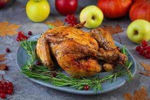 gebackenes ganzes Huhn oder Truthahn. gebratenes hausgemachtes Hähnchen mit Kräutern. Erntedankfest Dekoration foto