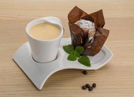 Kaffee mit Muffin auf Holzhintergrund foto