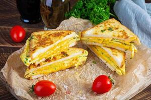 gerösteter French Toast mit Schinken, Ei, Kräutern und Käse-Cheddar. leckeres gegrilltes Frühstückssandwich foto