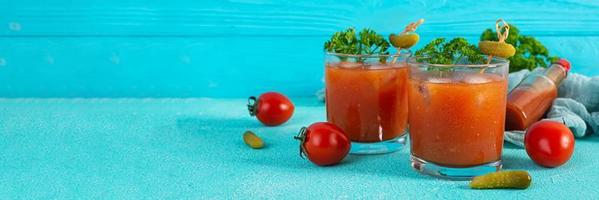 Alkoholcocktail Bloody Mary auf blauem Hintergrund. Klassischer Cocktail mit Tomatensaft und Wodka foto