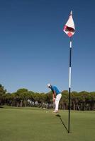 golfspieler, der an einem sonnigen tag einen schuss schlägt foto