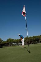 golfspieler, der an einem sonnigen tag einen schuss schlägt foto