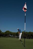 golfspieler, der an einem sonnigen tag einen schuss schlägt foto