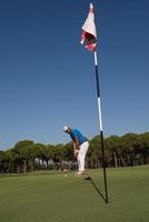 golfspieler, der an einem sonnigen tag einen schuss schlägt foto