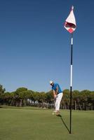 golfspieler, der an einem sonnigen tag einen schuss schlägt foto