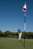 golfspieler, der an einem sonnigen tag einen schuss schlägt foto