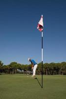 golfspieler, der an einem sonnigen tag einen schuss schlägt foto