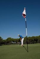 golfspieler, der an einem sonnigen tag einen schuss schlägt foto