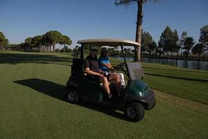 Golfspieler, die auf dem Platz Cart fahren foto