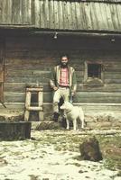 Hipster mit Hund vor Holzhaus foto