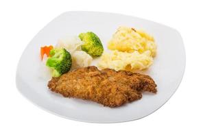 Schnitzel auf dem Teller und weißem Hintergrund foto