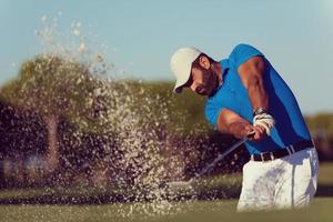 Profigolfer, der einen Sandbunkerschlag schlägt foto