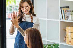 Produkte an Geschäftsinhaber online verkaufen. Konzentrieren Sie sich auf das Gesicht einer Frau in Weiß, die einer Freundin ihre Freude ausdrückt, deren Online-Verkäufe ihre Erwartungen übertroffen haben. foto