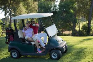 Paar im Buggy auf dem Golfplatz foto