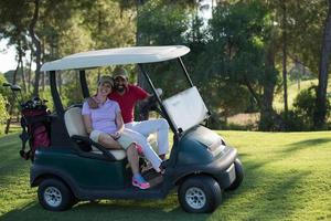 Paar im Buggy auf dem Golfplatz foto