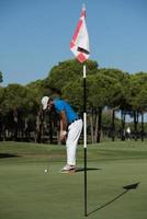 golfspieler, der an einem sonnigen tag einen schuss schlägt foto