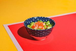 Poke Bowl mit Reis, Avocado, Edamame-Bohnen und Räucherlachs. hartes Licht, tiefer Schatten foto
