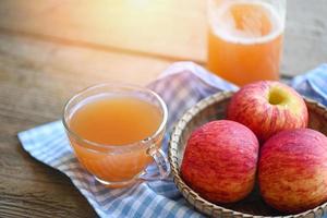 Apfelessig Naturheilmittel und Heilmittel für allgemeine Gesundheitszustände, roher und ungefilterter Bio-Apfelessig im Glas mit Apfelfrucht auf dem Holztisch foto